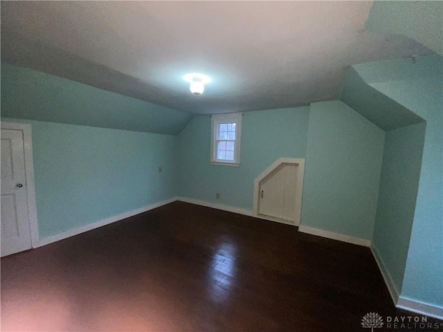 bonus room with hardwood / wood-style floors and vaulted ceiling