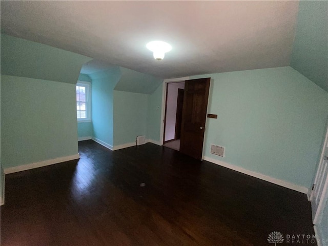 additional living space featuring lofted ceiling and dark hardwood / wood-style floors