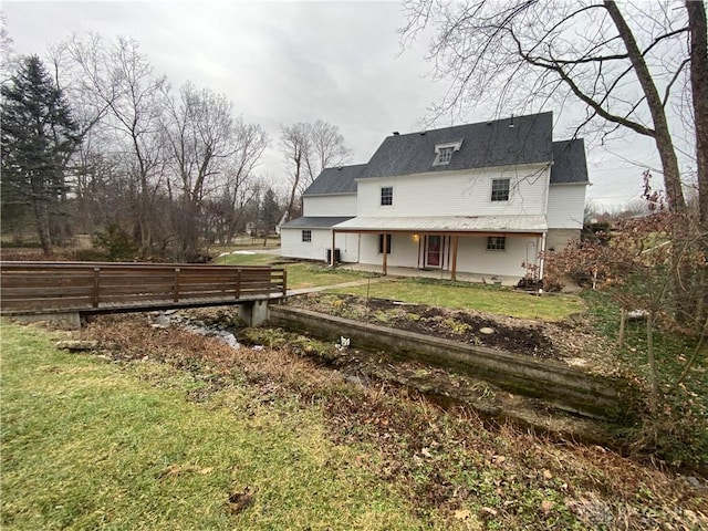 rear view of property featuring a lawn