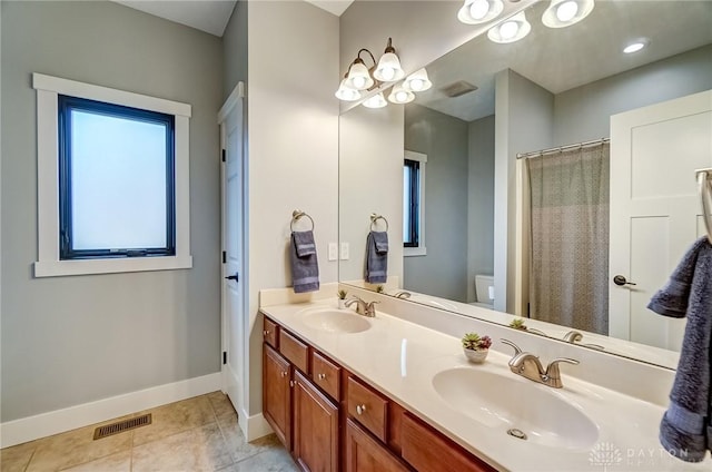 bathroom featuring tile patterned flooring, vanity, plenty of natural light, and toilet