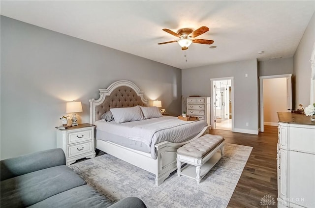 bedroom with dark hardwood / wood-style floors, ceiling fan, and ensuite bath