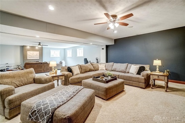 living room featuring light carpet, ceiling fan, and a textured ceiling