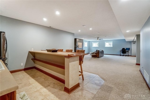 interior space featuring ceiling fan, light carpet, and stainless steel refrigerator