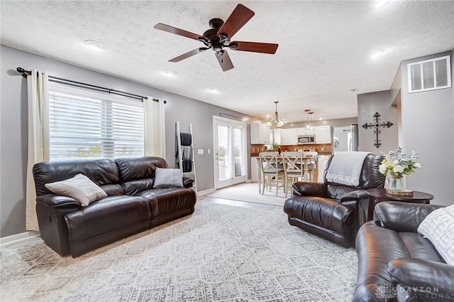 living room with ceiling fan and a textured ceiling