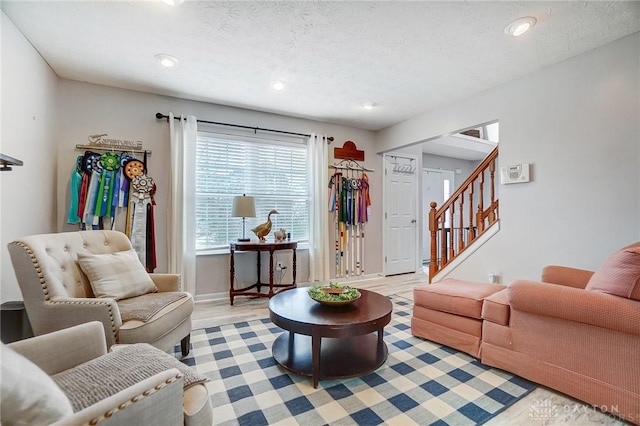 living room with light wood-type flooring and a textured ceiling