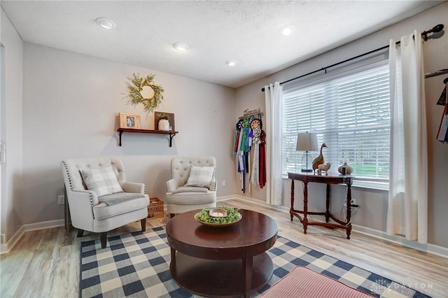 living area with light hardwood / wood-style flooring and a textured ceiling