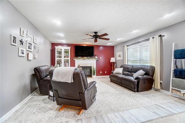 living room with ceiling fan, hardwood / wood-style floors, and a textured ceiling