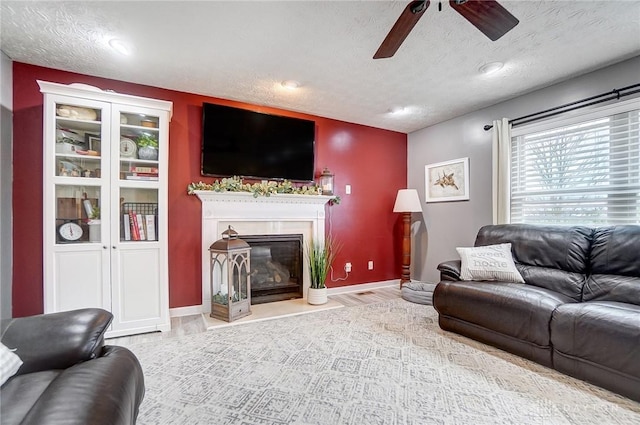 living room with ceiling fan, light hardwood / wood-style flooring, and a textured ceiling