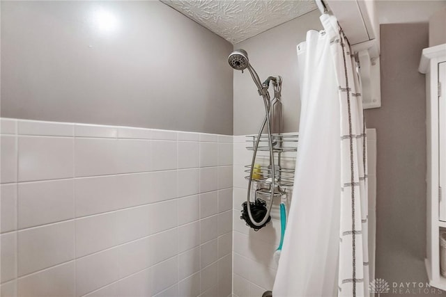 bathroom featuring curtained shower and a textured ceiling