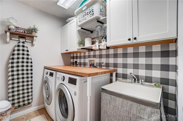 washroom with cabinets, independent washer and dryer, and sink