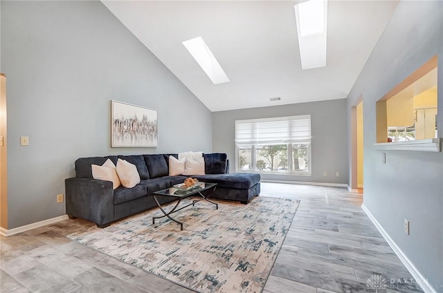 living room with light hardwood / wood-style floors, high vaulted ceiling, and a skylight