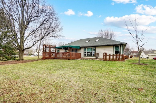 back of house with a deck and a lawn