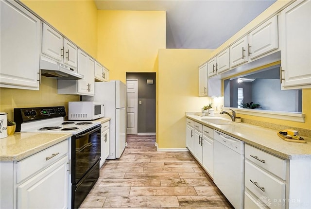 kitchen featuring sink, white cabinets, white appliances, and light hardwood / wood-style floors