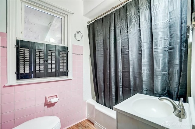 full bathroom with sink, tile walls, hardwood / wood-style flooring, toilet, and shower / bathtub combination with curtain