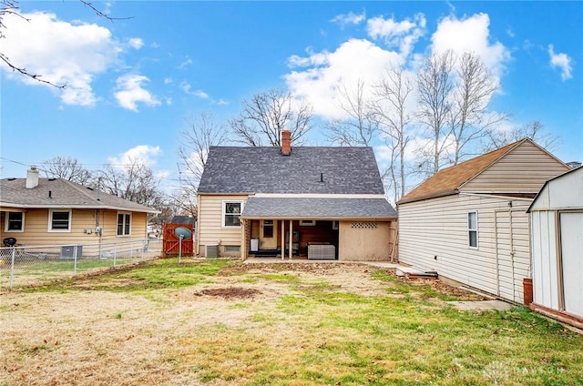 back of property with central AC, a storage shed, and a yard