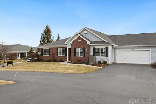 view of front of property with a garage, central AC, and a front yard