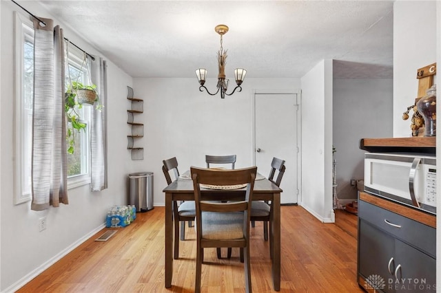 dining room with a chandelier and light hardwood / wood-style flooring