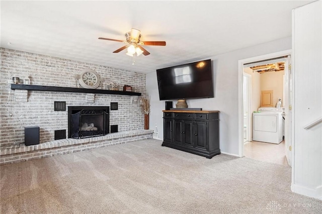 unfurnished living room with ceiling fan, a brick fireplace, light carpet, and washer and dryer