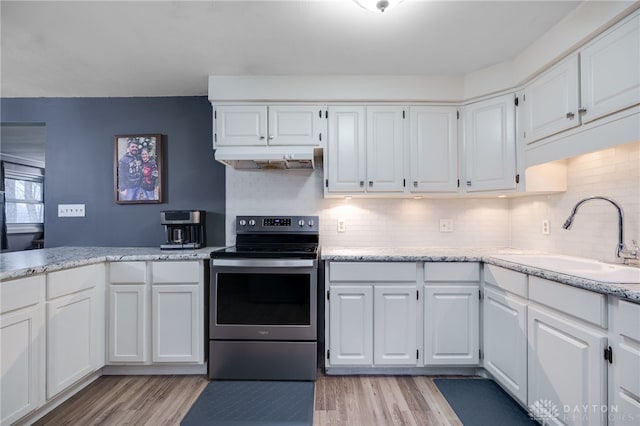 kitchen featuring white cabinets, sink, electric range, and light hardwood / wood-style flooring