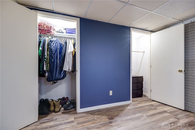 bedroom featuring wood-type flooring, a closet, and a drop ceiling