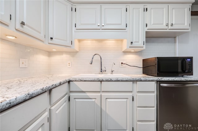 kitchen with tasteful backsplash, white cabinetry, sink, and stainless steel dishwasher