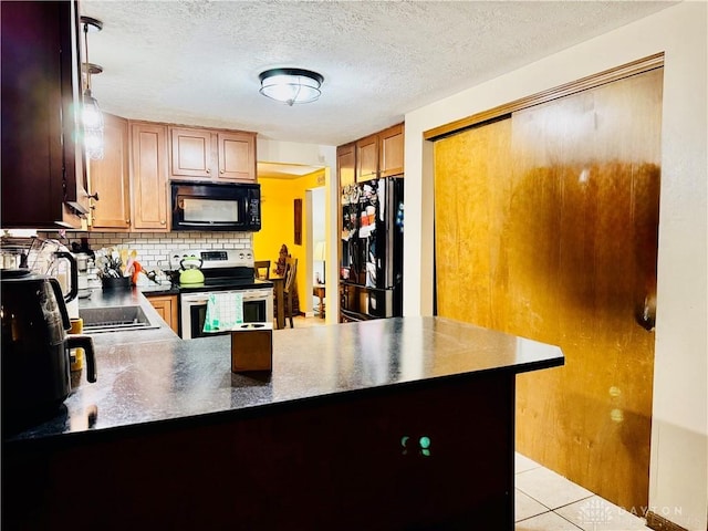 kitchen featuring tasteful backsplash, black appliances, kitchen peninsula, and light tile patterned flooring