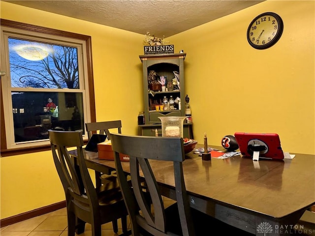 tiled dining room with a textured ceiling