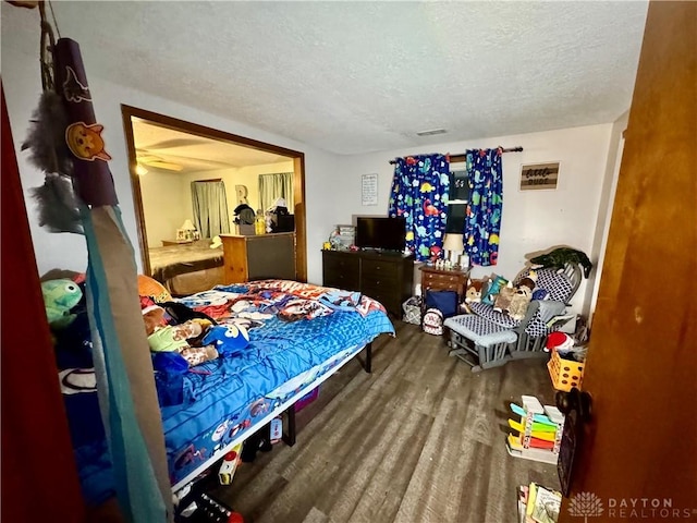 bedroom featuring hardwood / wood-style flooring and a textured ceiling