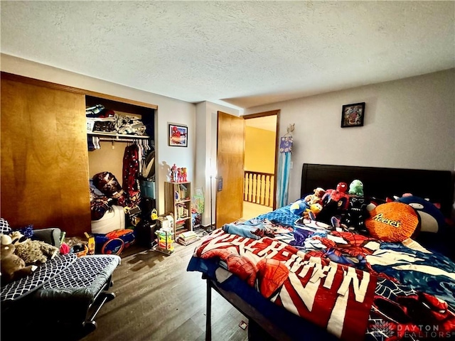 bedroom featuring wood-type flooring, a closet, and a textured ceiling