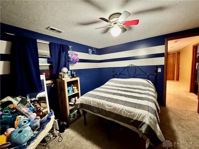 bedroom featuring ceiling fan, carpet floors, and a textured ceiling