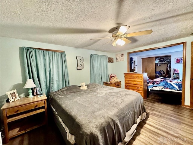 bedroom featuring hardwood / wood-style flooring, ceiling fan, and a textured ceiling