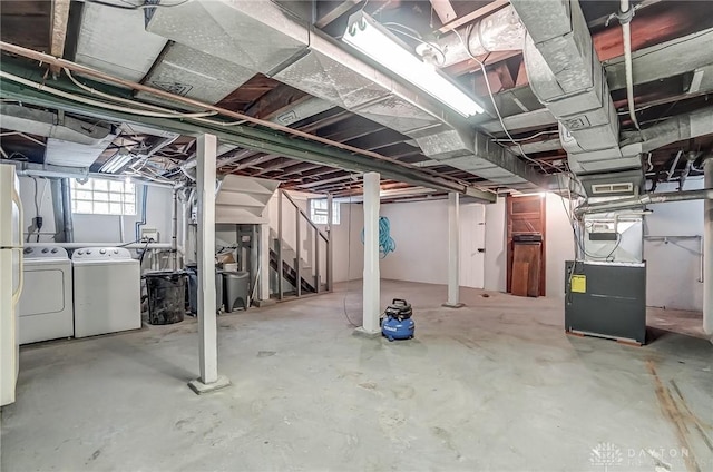 basement featuring washer and clothes dryer and heating unit