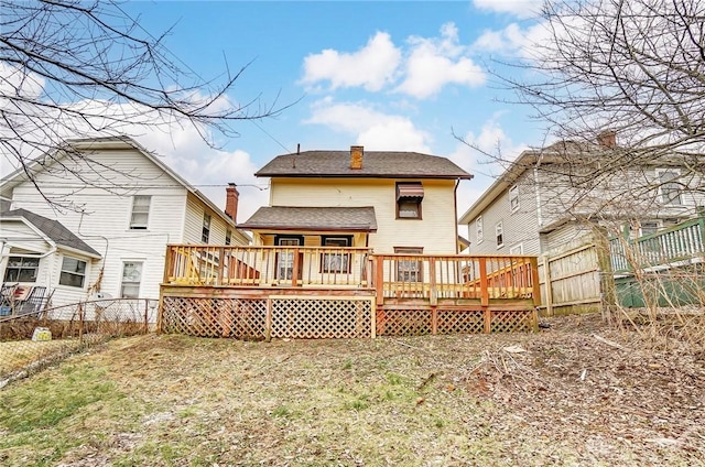 rear view of house with a yard and a deck