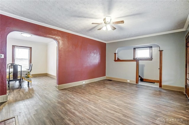 empty room with crown molding, ceiling fan, hardwood / wood-style floors, and a textured ceiling