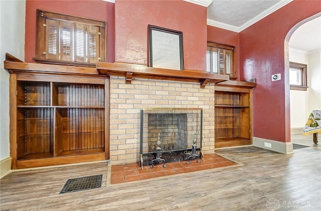 unfurnished living room featuring crown molding, a healthy amount of sunlight, hardwood / wood-style floors, and a textured ceiling