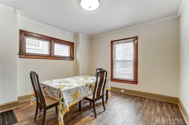 dining room with crown molding and dark hardwood / wood-style flooring