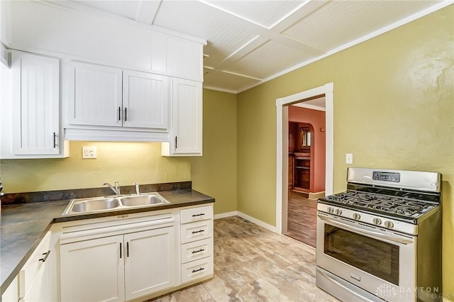 kitchen with sink, gas stove, and white cabinets