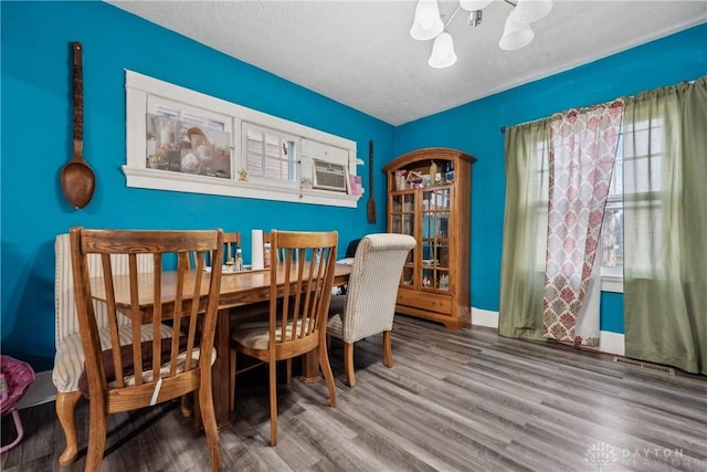 dining area featuring hardwood / wood-style flooring, cooling unit, and a textured ceiling