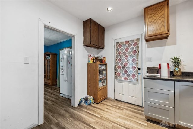 kitchen featuring white fridge with ice dispenser and light wood-type flooring