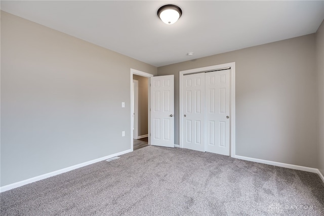 unfurnished bedroom featuring carpet flooring and a closet