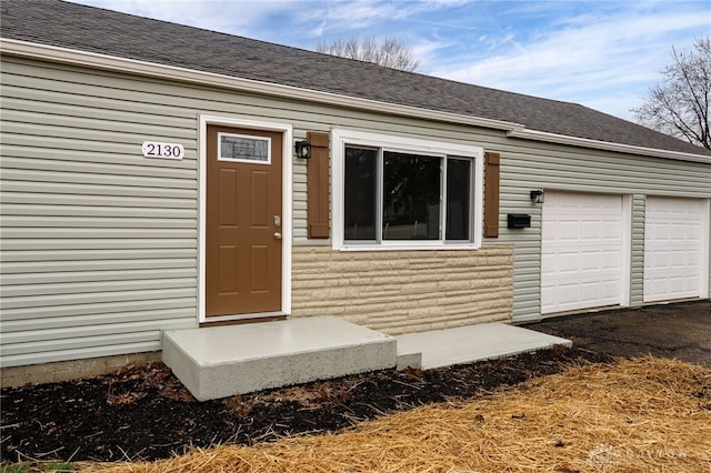 doorway to property with a garage