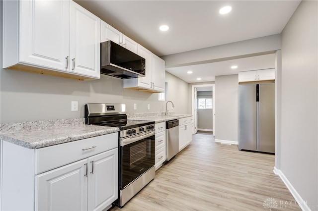 kitchen featuring sink, light hardwood / wood-style flooring, white cabinets, and appliances with stainless steel finishes