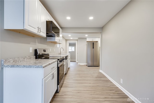 kitchen featuring stainless steel appliances, light hardwood / wood-style floors, sink, and white cabinets