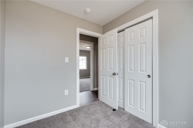 unfurnished bedroom with light carpet and a closet