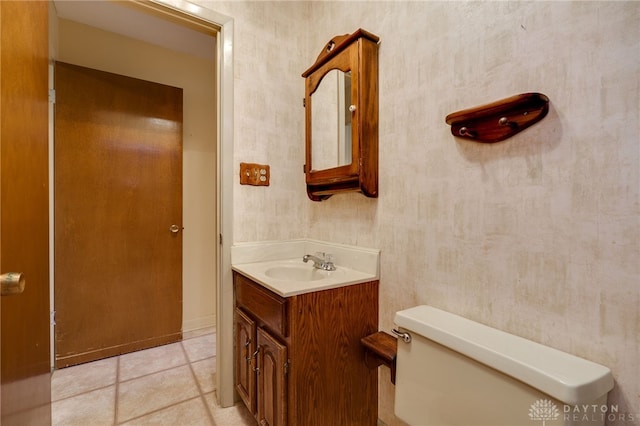 bathroom with tile patterned flooring, vanity, and toilet