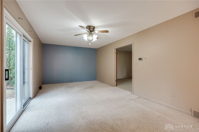 unfurnished room featuring light colored carpet, ceiling fan, visible vents, and baseboards