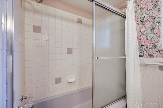 bathroom with wainscoting, bathtub / shower combination, and tile walls