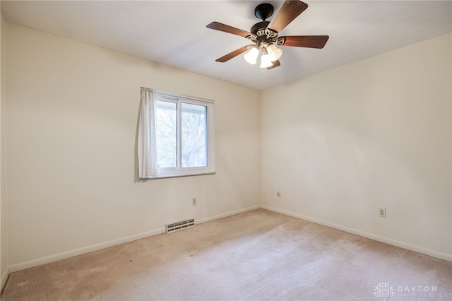 unfurnished room featuring light carpet, baseboards, visible vents, and a ceiling fan