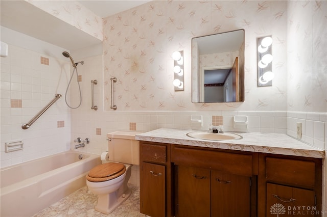 full bath with wallpapered walls, toilet, a wainscoted wall, vanity, and shower / bathing tub combination