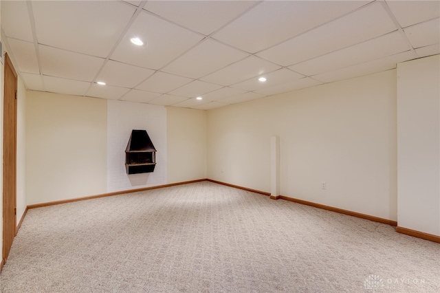 carpeted empty room featuring a drop ceiling, recessed lighting, and baseboards